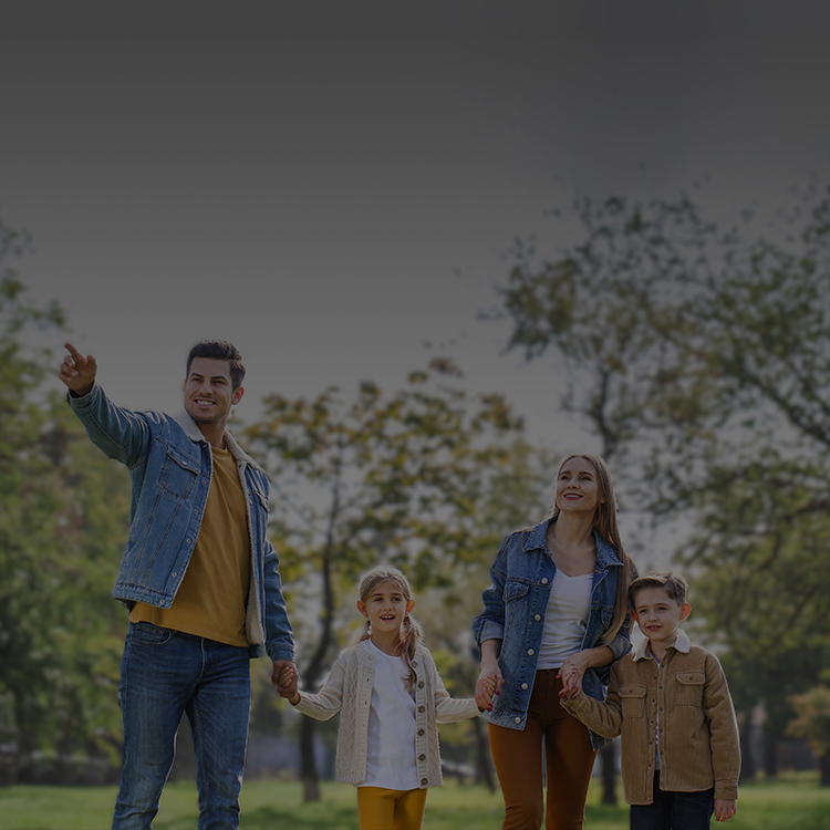 A family enjoying a walk in a green park under a clear sky, reflecting harmony and togetherness.